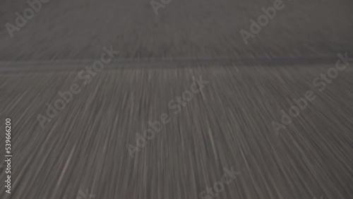 Closeup of asphalt road with fast movement. Fooage. Summer road with white stirpes.