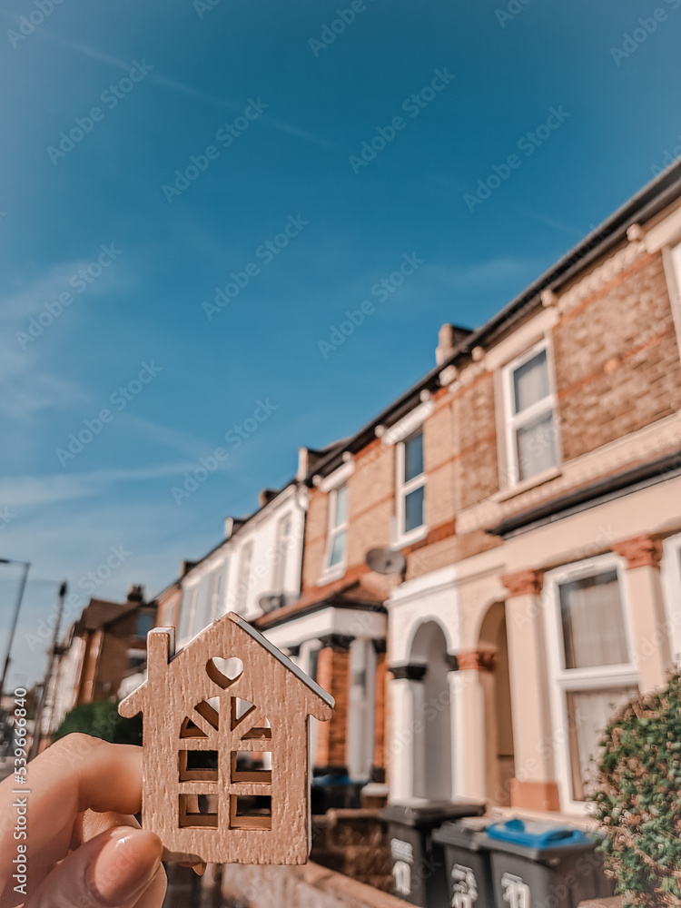 Woman's hand holding Keychain in the shape of house real estate concept Woman's hand holding Keychain in the shape of house real estate concept