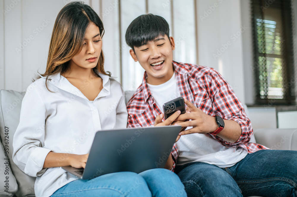 Attractive Young couple use laptop computer working with happiness Attractive Young couple use laptop computer working with happiness