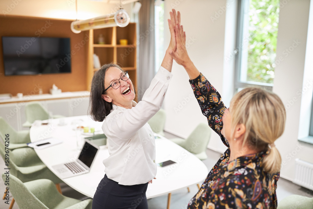 Fröhliche Business Frauen feiern Erfolg mit High Five Fröhliche Business Frauen feiern Erfolg mit High Five