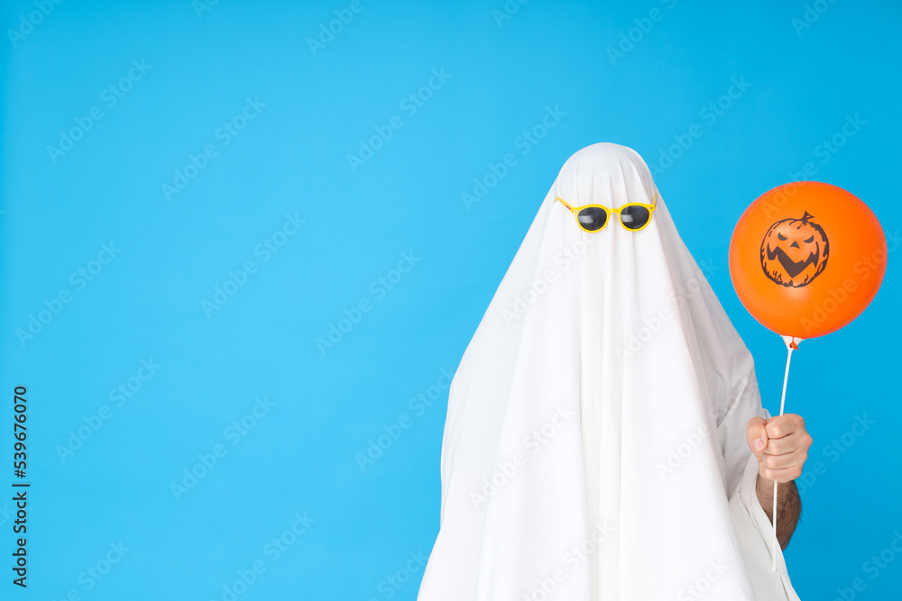 Concept of Halloween, Ghost in sunglasses on blue background