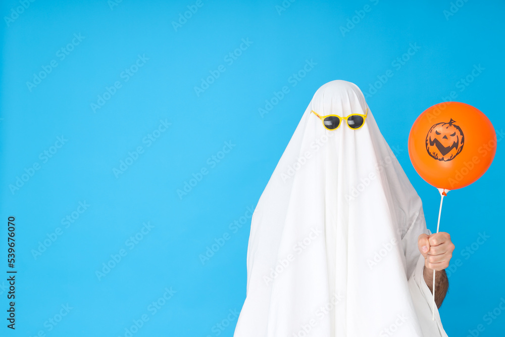 Concept of Halloween, Ghost in sunglasses on blue background Concept of Halloween, Ghost in sunglasses on blue background