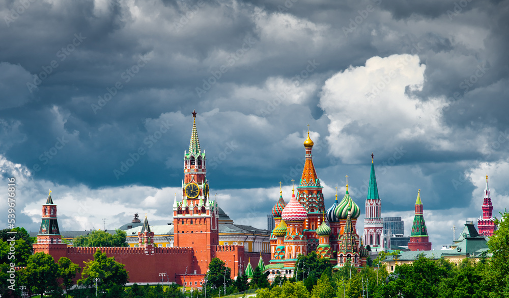 Spasskaya Tower of Moscow Kremlin and Cathedral of Vasily the Blessed (Saint Basil's Cathedral) on Red Square in summer day. Black clouds before the rain. Panorama. Moscow. Russia Spasskaya Tower of Moscow Kremlin and Cathedral of Vasily the Blessed (Saint Basil's Cathedral) on Red Square in summer day. Black clouds before the rain. Panorama. Moscow. Russia