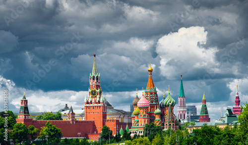 Spasskaya Tower of Moscow Kremlin and Cathedral of Vasily the Blessed (Saint Basil's Cathedral) on Red Square in summer day. Black clouds before the rain. Panorama. Moscow. Russia