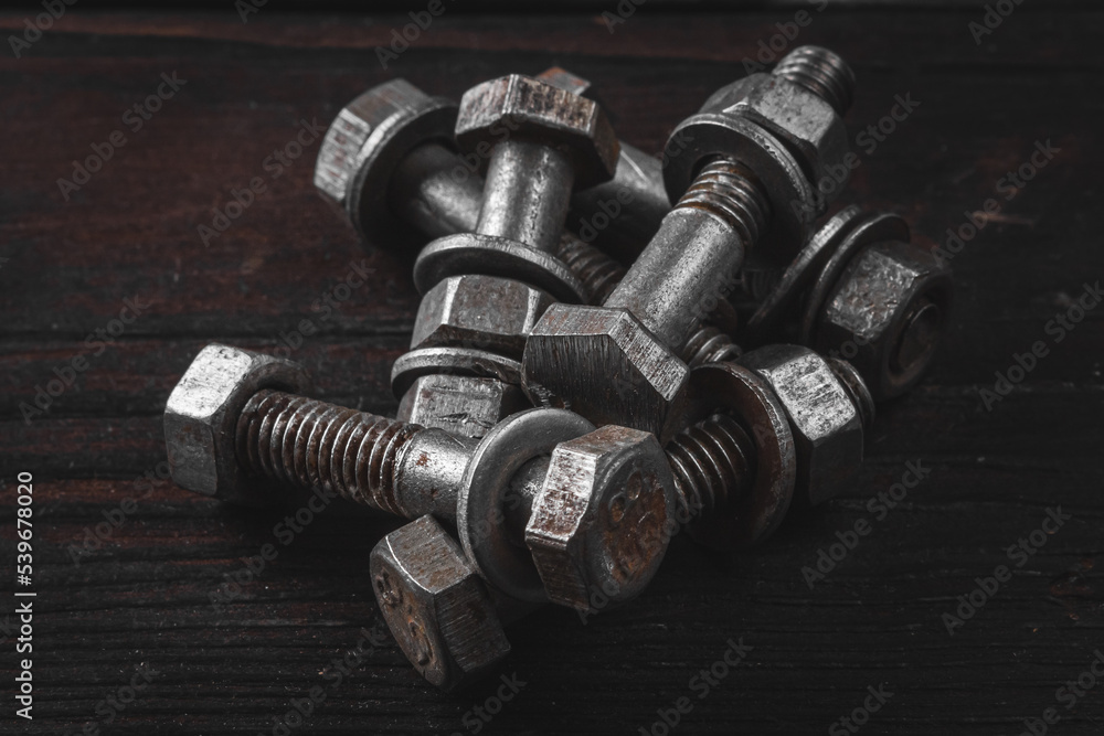 Steel bolts on a wooden table. Bolt with nut. Mounting bolts.