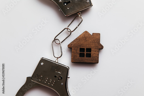 Handcuffs and house. Crime and fraud in housing