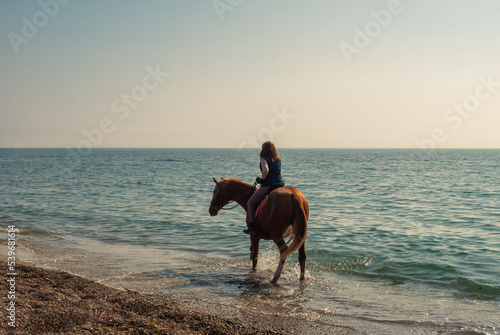 Selective focus. Girl and horse. Horse riding by the sea.