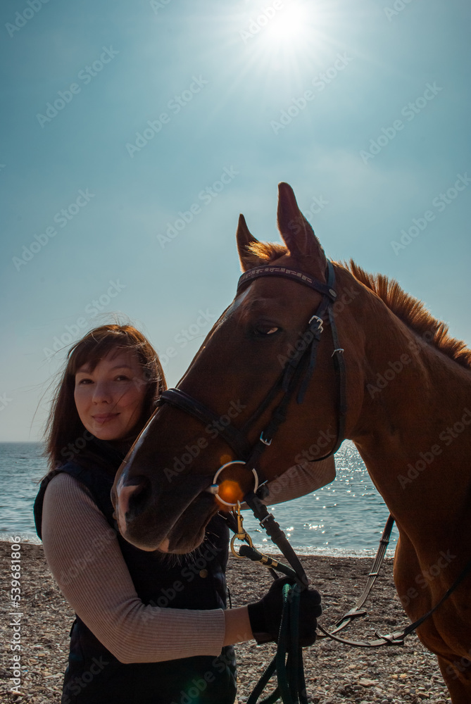Selective focus. Girl and horse. Horse riding by the sea. Selective focus. Girl and horse. Horse riding by the sea.
