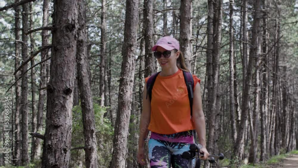 Girl hiking in a forest. Front view walking towards camera. Girl hiking in a forest. Front view walking towards camera.