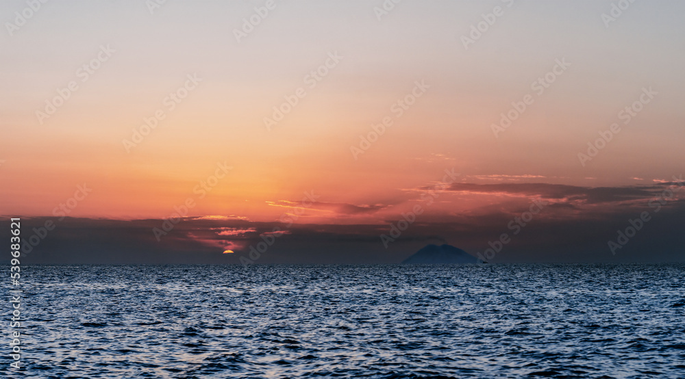 Stromboli volcano smoke and sunset over Tyrrhenian, Mediterranean Sea.  View from Coast of Gods, Calabria, southern Italy.