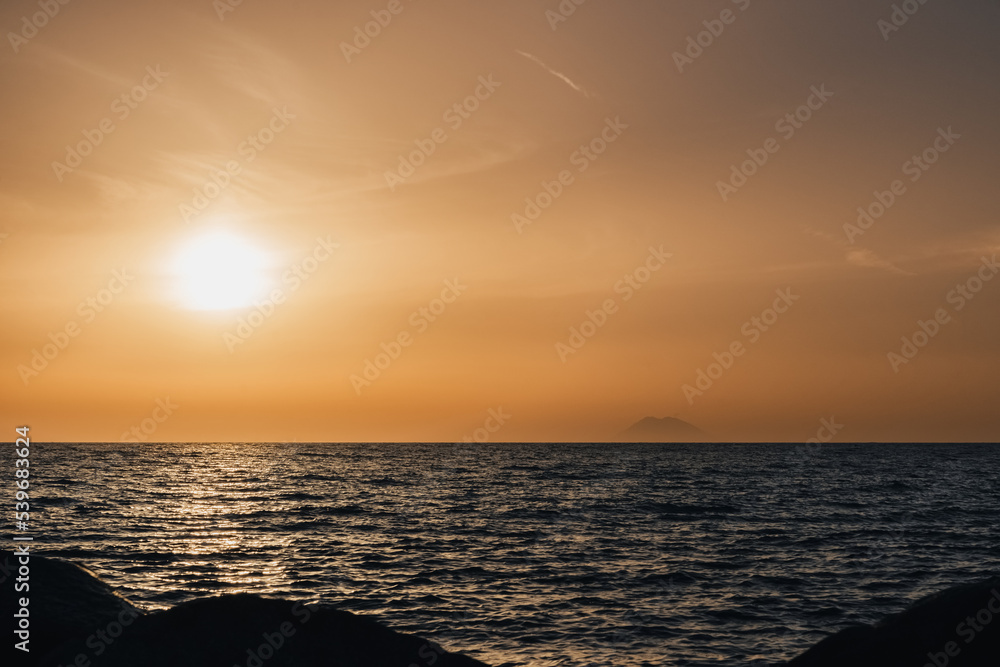 Stromboli volcano smoke and sunset over Tyrrhenian, Mediterranean Sea.  View from Coast of Gods, Calabria, southern Italy.