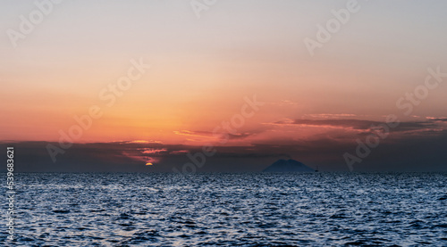 Stromboli volcano smoke and sunset over Tyrrhenian, Mediterranean Sea. View from Coast of Gods, Calabria, southern Italy.