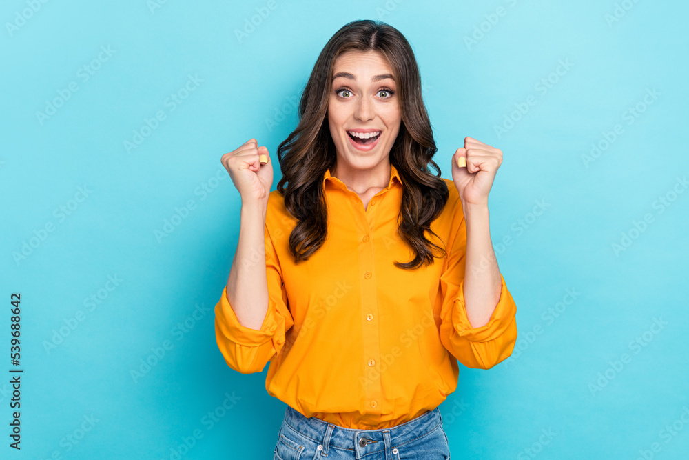 Fototapeta premium Photo portrait of nice young woman raise fists celebrate award lucky wear trendy yellow smart casual look isolated on blue color background