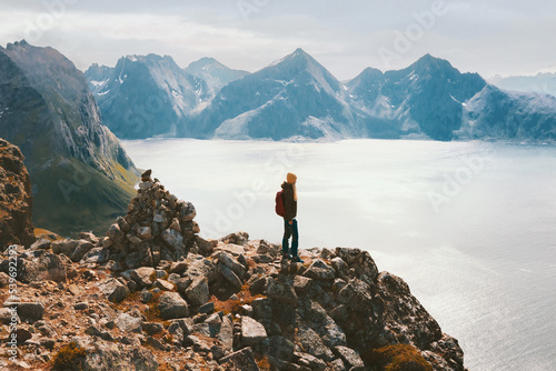 Hiker woman traveling in Norway adventure active vacations outdoor healthy lifestyle trip aerial fjord view climbing Brosmetinden mountain