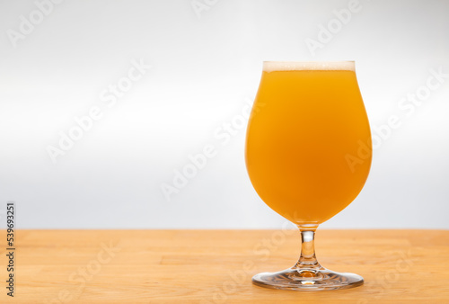 Full tulip glass of NEIPA ale beer on a table photo