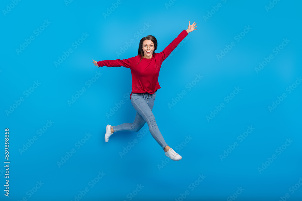Full body photo of celebrate young lady run wear eyewear shirt jeans shoes isolated on blue background Full body photo of celebrate young lady run wear eyewear shirt jeans shoes isolated on blue background