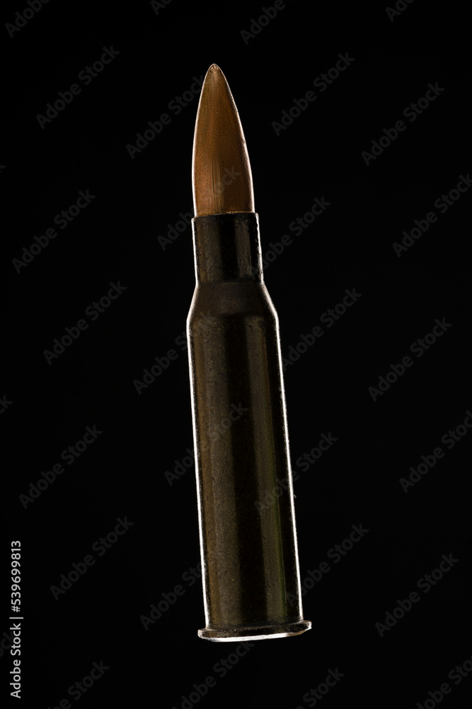 Rifle bullet long cartridge on black background. Army or hunting weapon shot object, violence and danger symbol. Rifle bullet long cartridge on black background. Army or hunting weapon shot object, violence and danger symbol.