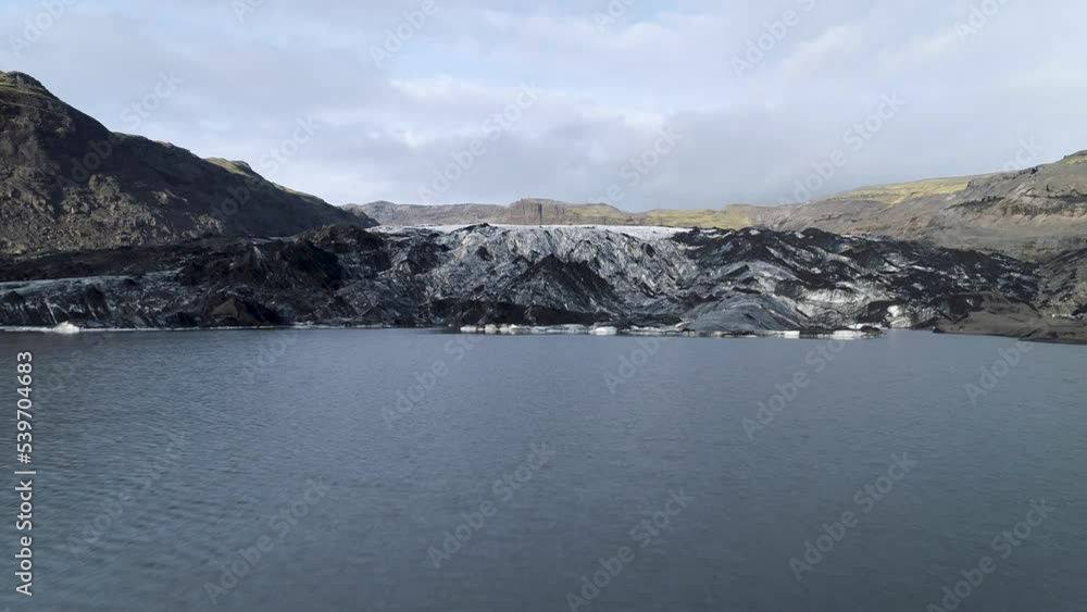 Aerial drone camera shot from flight over the glacier in Iceland. In the picture you can see dirty melting ice array from above. Aerial drone camera shot from flight over the glacier in Iceland. In the picture you can see dirty melting ice array from above.