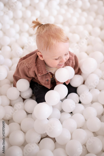 A child is sitting in a balloon pool © Jelena