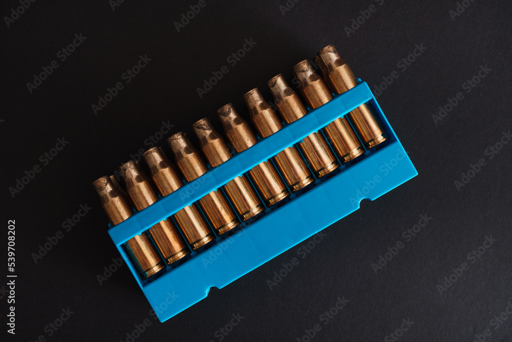 Amber gold empty bullet cases in blue holder Amber gold empty bullet cases in blue holder
