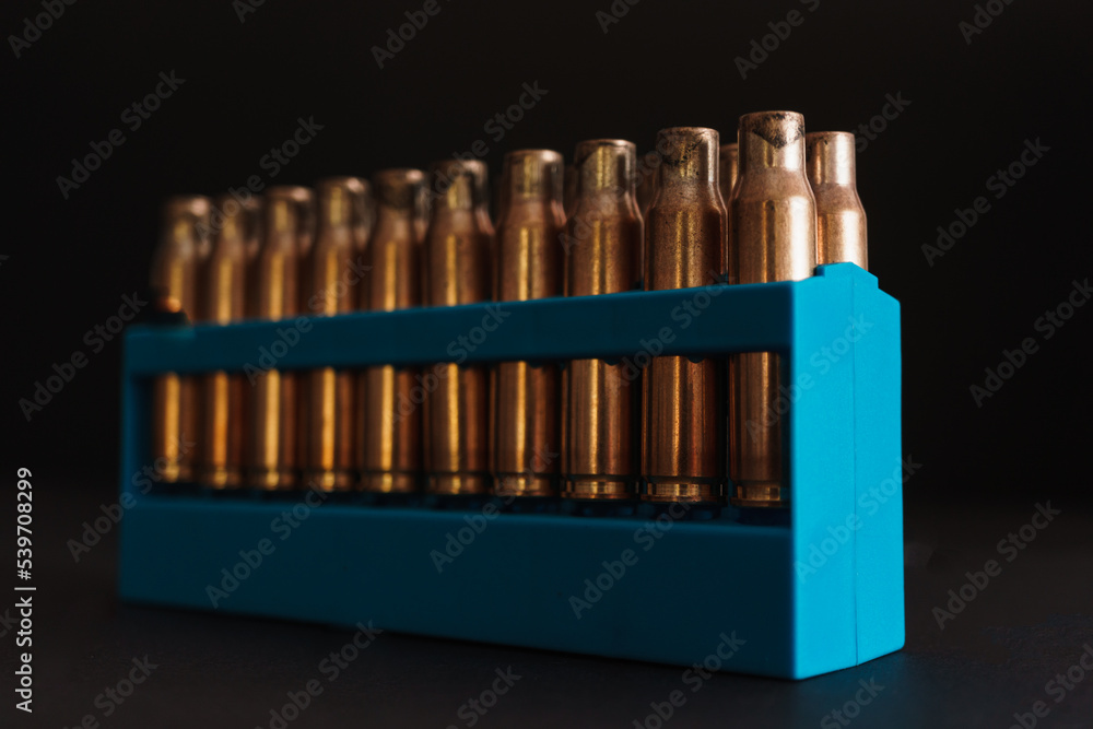 Amber gold empty bullet cases in blue holder Amber gold empty bullet cases in blue holder