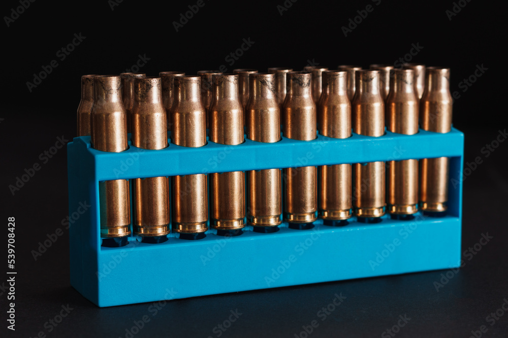 Amber gold empty bullet cases in blue holder Amber gold empty bullet cases in blue holder