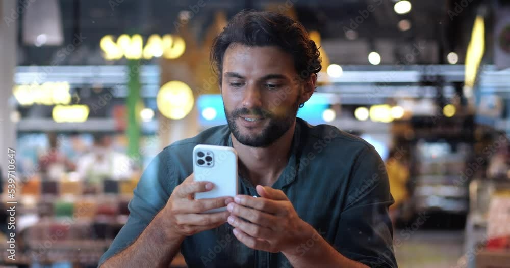 Attractive relaxed Caucasian bearded macho man using mobile phone, scrolling newsfeed, browsing websites, networking, checking content in social media, chatting online. Communicate across the distance Attractive relaxed Caucasian bearded macho man using mobile phone, scrolling newsfeed, browsing websites, networking, checking content in social media, chatting online. Communicate across the distance