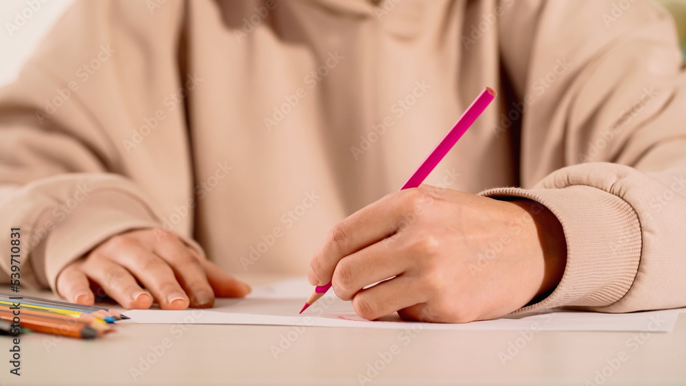 Cropped view of woman drawing with color pencil at home. Cropped view of woman drawing with color pencil at home.