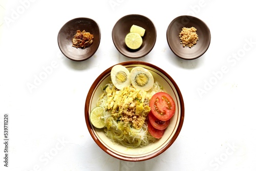 Soto Lamongan is a dish of Soup Lamongan, East Java, Indonesia. made of chicken, vermicelli, egg, bean sprout, turmeric, the broth and koya photo