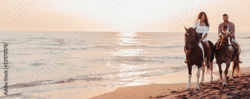 The family spends time with their children while riding horses together on a sandy beach. Selective focus 