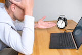 Man confused and holds your head while working on laptop