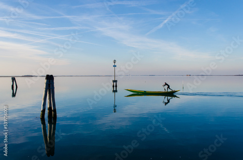 La silhouette di un uomo che rema sulla sua barca di fronte all'isola di Pellestrinanella luce del tramonto