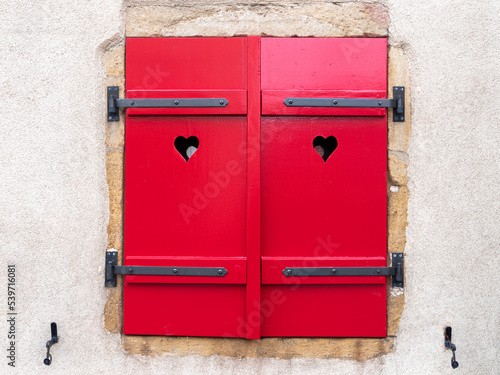 Closed red window shutters with hearts in Alsace, France