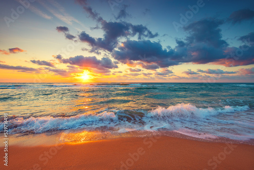 Fototapeta Naklejka Na Ścianę i Meble -  Beautiful sunrise over the sea waves and beach on tropical island