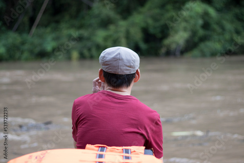 Portrait photo of an Asian man looking man with handsome having a nice time outdoors in a vacation forest by the River. relaxing, happy, and fun with a vacation. © Monta