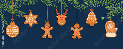 christmas card with hanging gingerbread cookies decoration and fir branches