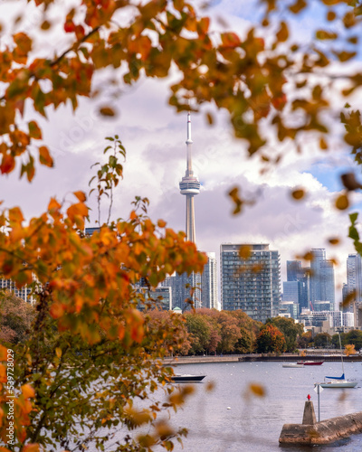 Colorful fall foliage framing the Toronto skyline from Ontario Place and Inukshuk park