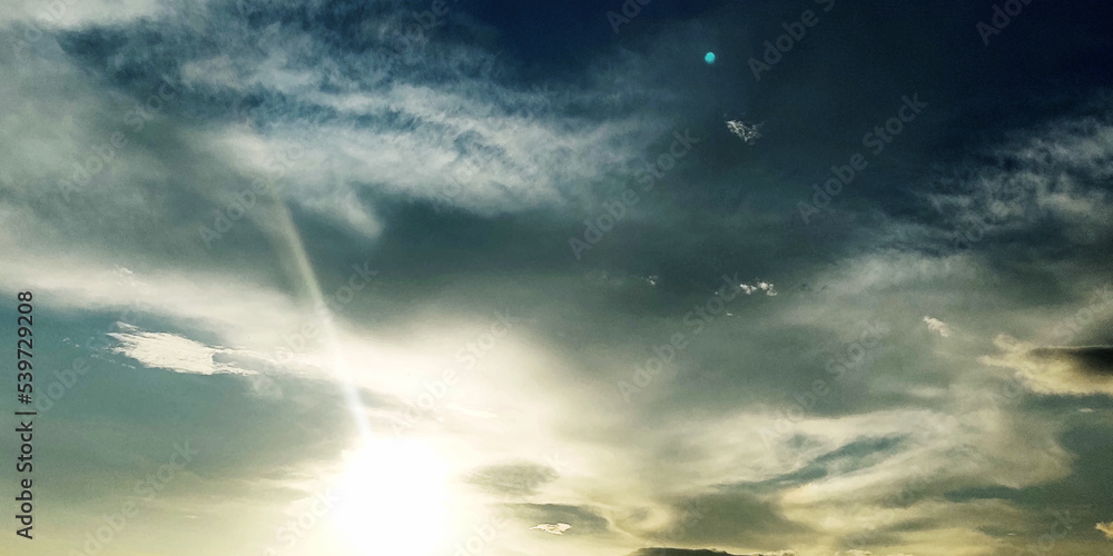 Beautiful sunset sky, the sun leaving bright golden shades background with clouds in sunny day. 