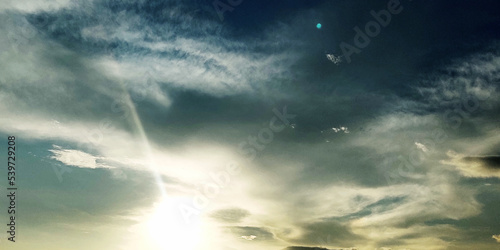 Beautiful sunset sky, the sun leaving bright golden shades background with clouds in sunny day.  © Ahmad Araf