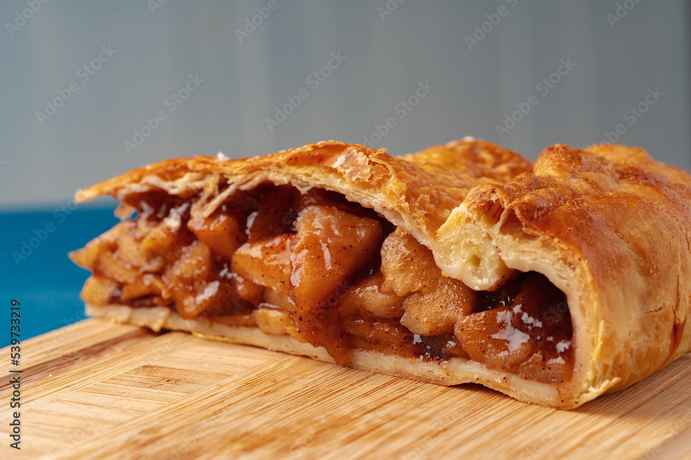 Apple pie on a wooden board cut into pieces