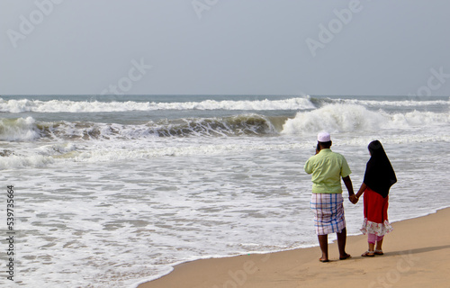 Two person standing at the shore of the Bay of Bengal photo