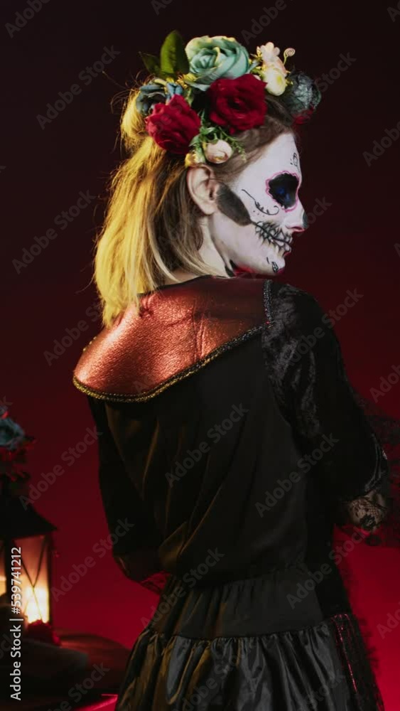 Vertical video: Scary horror woman trying to lure with hand, reach and tempt victims in studio. Flirty la cavalera catrina model with mexican festival costume on holiday celebration, day of the dead. Vertical video: Scary horror woman trying to lure with hand, reach and tempt victims in studio. Flirty la cavalera catrina model with mexican festival costume on holiday celebration, day of the dead.
