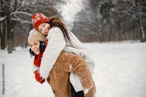 Teen girl and her mother having fun at winter park