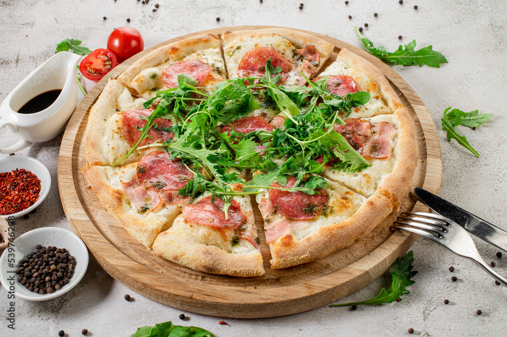 Meat pizza with ham and cheese on the white concrete background