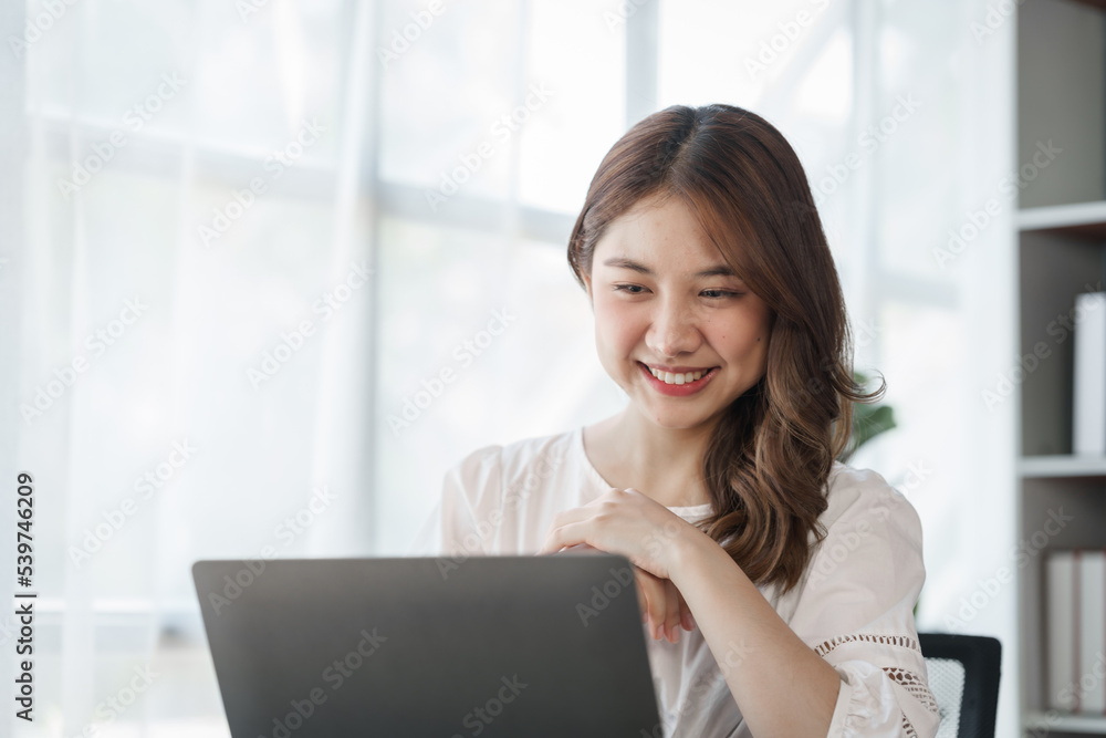 Smile Pretty business Asian woman freelancer is working her job on a laptop computer in a modern office. Doing accounting analysis report real estate investment data, Financial and tax systems concept Smile Pretty business Asian woman freelancer is working her job on a laptop computer in a modern office. Doing accounting analysis report real estate investment data, Financial and tax systems concept
