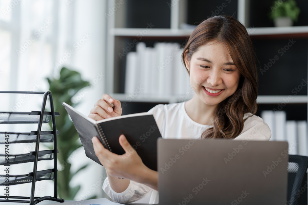 Smile Pretty business Asian woman freelancer is working her job on a laptop computer in a modern office. Doing accounting analysis report real estate investment data, Financial and tax systems concept Smile Pretty business Asian woman freelancer is working her job on a laptop computer in a modern office. Doing accounting analysis report real estate investment data, Financial and tax systems concept