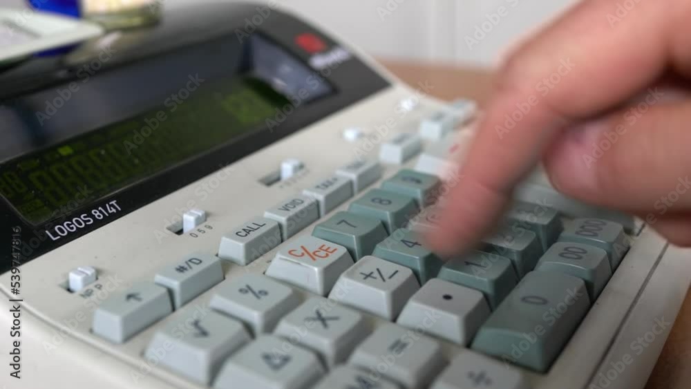 Human hand using a calculator. The concept of managing the company's finances for accuracy and growth. Human hand using a calculator. The concept of managing the company's finances for accuracy and growth.