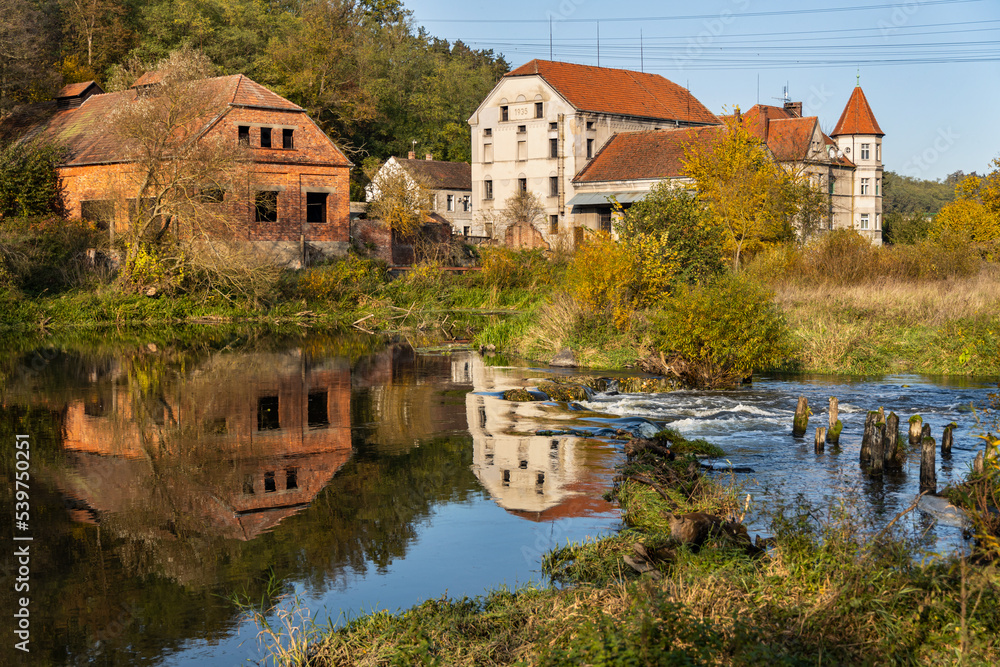 Autumn view of Berounka river with remains of the Dolany mill (Dolansky mlyn) and their reflections in the river. Pilsen, the Czech republic.
