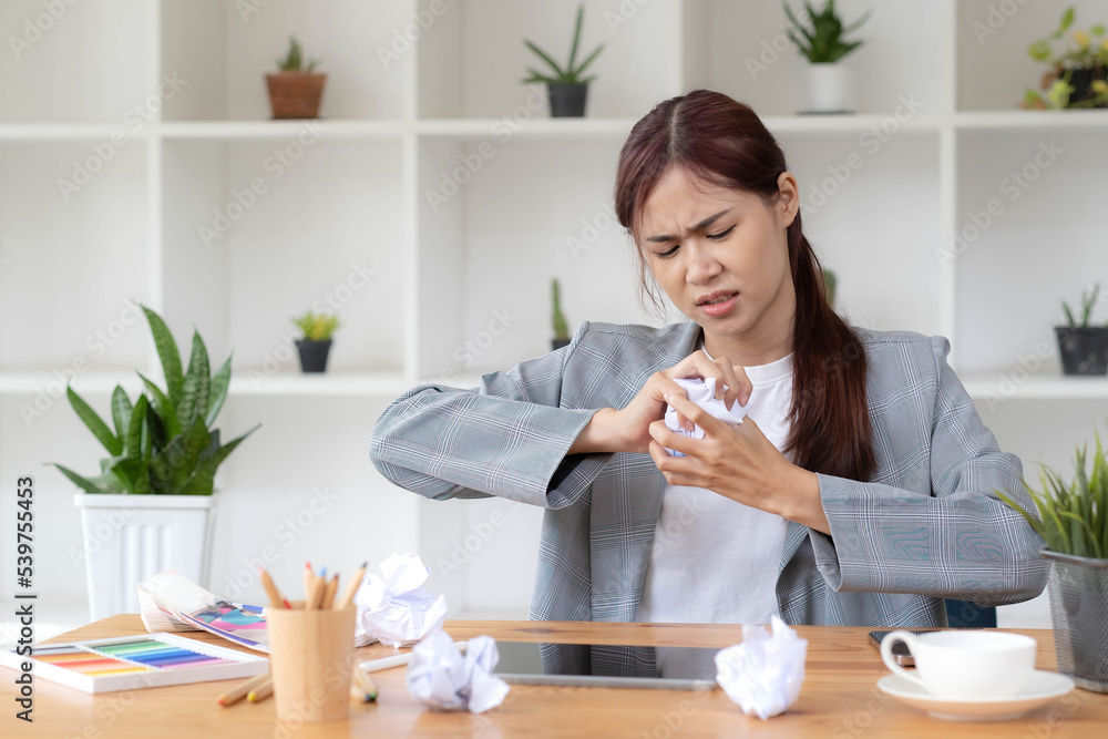 Mad Angry Stressed young asian female graphic designer or businesswoman with a crumpling paper on the table dissatisfied with her work, complained from her boss, getting a job problem. Mad Angry Stressed young asian female graphic designer or businesswoman with a crumpling paper on the table dissatisfied with her work, complained from her boss, getting a job problem.