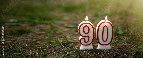 Burning candles in the form of numbers 90. Candles set on the ground with the ninetieth anniversary. Congratulations on the anniversary. photo